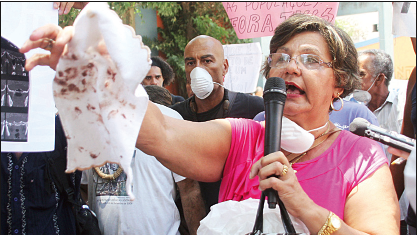 Moradora mostra os resíduos do material e da poeira inalados pela população local. Foto: Clarice Castro